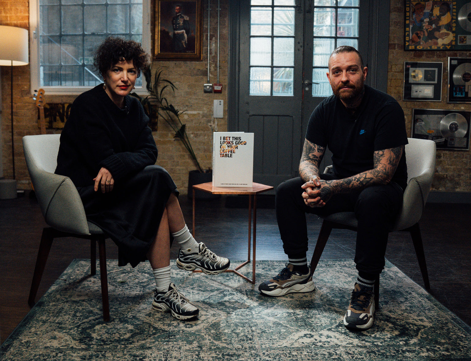 Load video: Annie Mac and Andy Nicholson sat on two grey chairs with a coffee table between them, on the coffee table is Andy&#39;s book &#39;I Bet This Looks Good On Your Coffee Table&#39;. Press play to watch the interview.